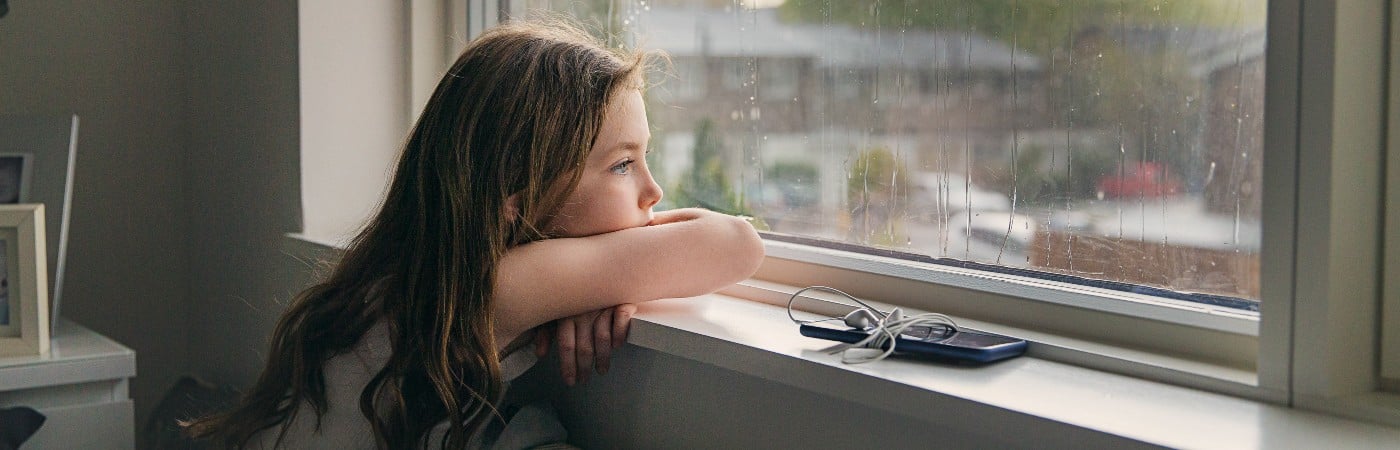 Anxiety in children - anxious girl looking out of window